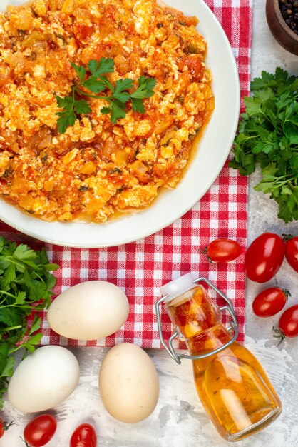 Vue de dessus délicieuse omelette aux tomates avec des verts et des légumes frais sur fond blanc matin petit déjeuner pain déjeuner