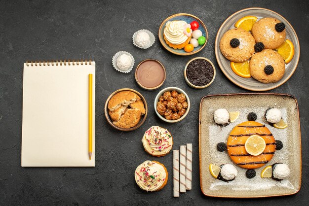 Vue de dessus délicieuse petite tarte aux biscuits et gâteau sur une surface gris foncé gâteau au thé biscuit biscuit sucré