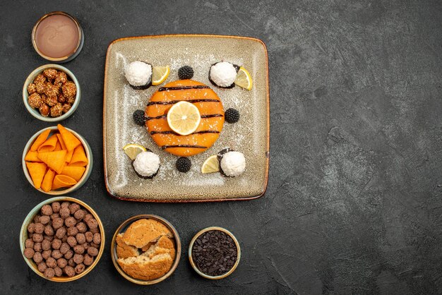 Vue de dessus délicieuse petite tarte aux bonbons à la noix de coco sur fond gris foncé biscuit gâteau tarte biscuit bonbons sucré