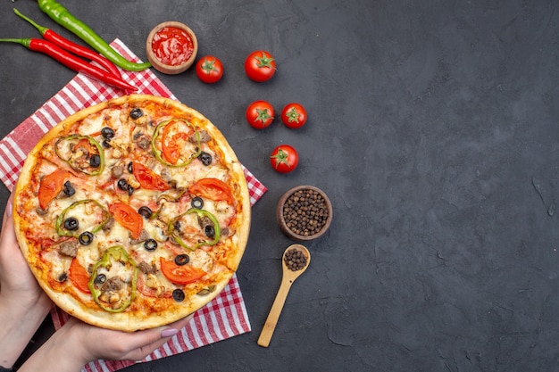 Vue de dessus délicieuse pizza au fromage aux olives, poivrons et tomates sur une surface sombre