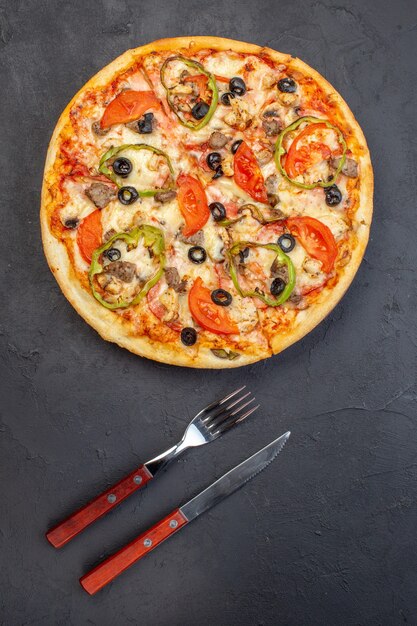 Vue de dessus délicieuse pizza au fromage aux olives, poivrons et tomates sur une surface sombre