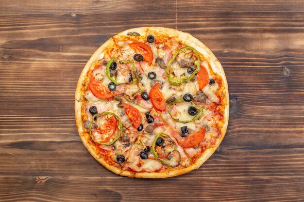 Vue de dessus délicieuse pizza au fromage sur une surface en bois brune