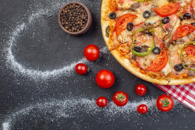 Vue de dessus délicieuse pizza au fromage avec des tomates rouges sur fond sombre