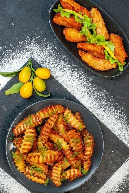 Vue de dessus délicieuse pomme de terre frite avec des légumes verts à l'intérieur de la plaque sur un fond sombre cuisson friture repas repas plat viande photo