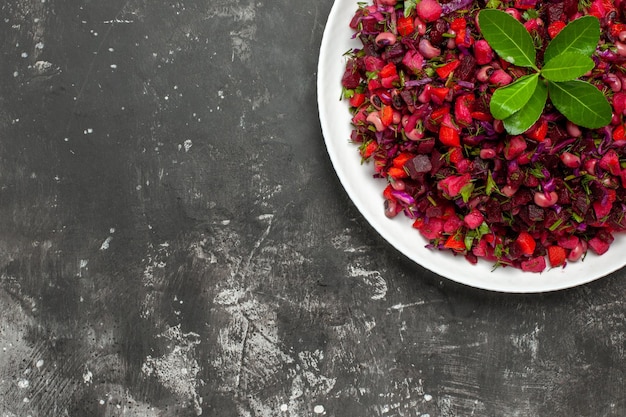 Vue de dessus délicieuse salade de betteraves vinaigrette avec des haricots sur la surface sombre