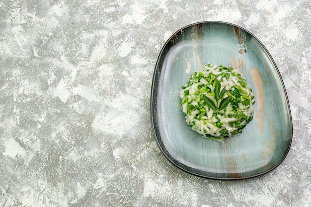 Vue de dessus une délicieuse salade composée de légumes verts et de chou à l'intérieur d'une assiette