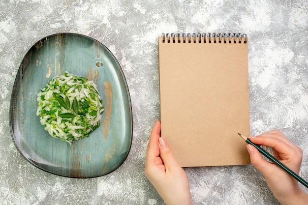 Photo gratuite vue de dessus une délicieuse salade composée de légumes verts et de chou à l'intérieur d'une assiette