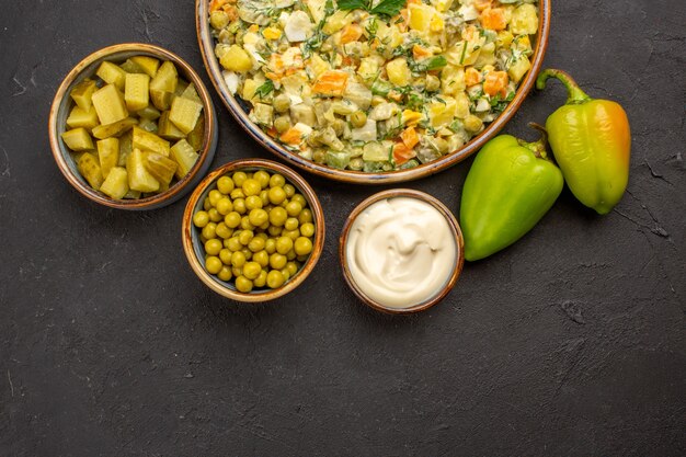 Vue de dessus de la délicieuse salade avec des ingrédients sur une surface sombre