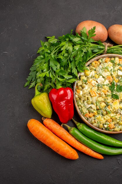 Vue de dessus de la délicieuse salade avec des légumes frais sur une surface sombre