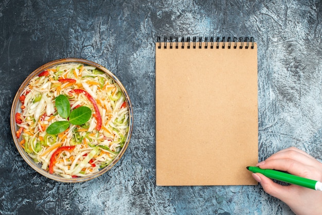 Vue de dessus délicieuse salade de légumes à l'intérieur du plateau sur fond gris