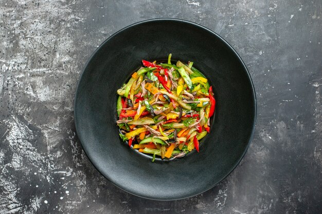 Vue de dessus délicieuse salade de légumes à l'intérieur de la plaque sur fond gris