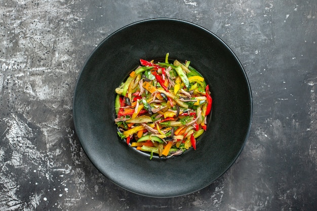 Vue de dessus délicieuse salade de légumes à l'intérieur de la plaque sur fond gris