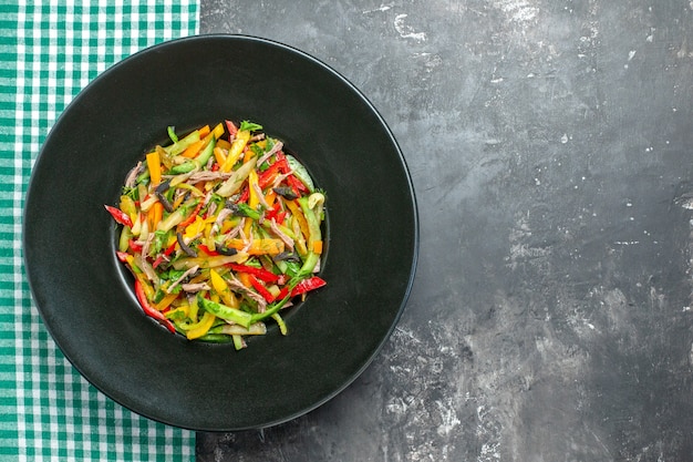 Vue de dessus délicieuse salade de légumes à l'intérieur de la plaque sur fond gris