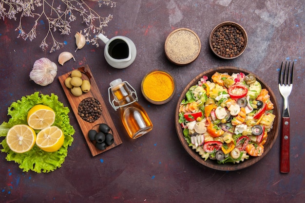 Vue de dessus une délicieuse salade de légumes avec des tomates en tranches, des olives et des champignons sur fond sombre repas salade régime alimentaire santé