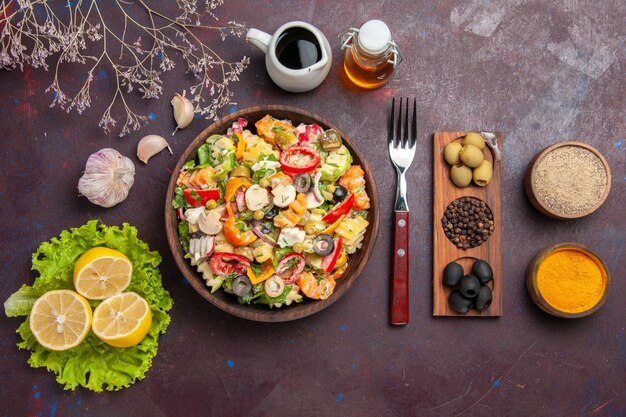 Vue de dessus délicieuse salade de légumes avec des tranches de citron sur fond sombre repas régime salade aliments santé