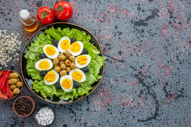 Vue de dessus délicieuse salade d'oeufs aux tomates et olives sur fond clair