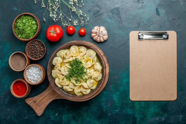 Vue de dessus délicieuse soupe aux boulettes avec différents assaisonnements sur la surface verte soupe alimentaire légumes pâte viande