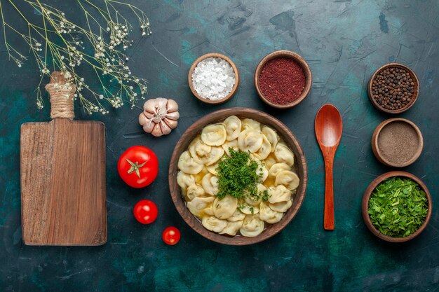 Vue de dessus délicieuse soupe aux boulettes avec différents assaisonnements sur la surface verte soupe à la viande pâte à légumes