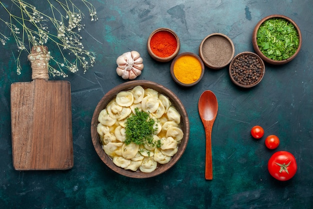 Vue de dessus délicieuse soupe aux boulettes avec des légumes verts et différents assaisonnements sur la surface sombre de la pâte à soupe de la nourriture végétale