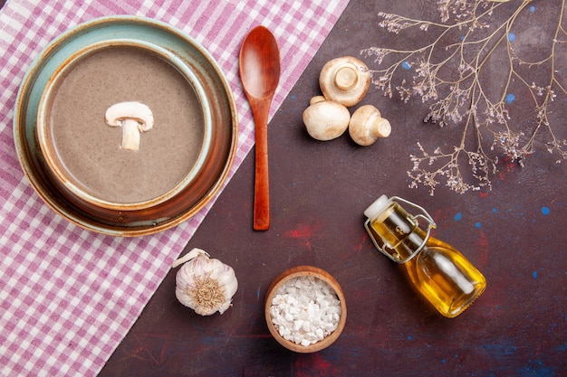 Vue de dessus délicieuse soupe aux champignons avec de l'huile sur un espace sombre