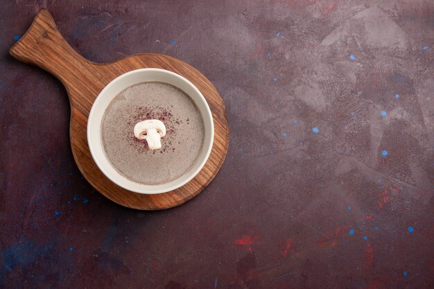 Vue de dessus délicieuse soupe aux champignons à l'intérieur de la plaque sur l'espace sombre