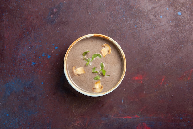 Vue de dessus délicieuse soupe aux champignons à l'intérieur de la plaque sur l'espace violet foncé