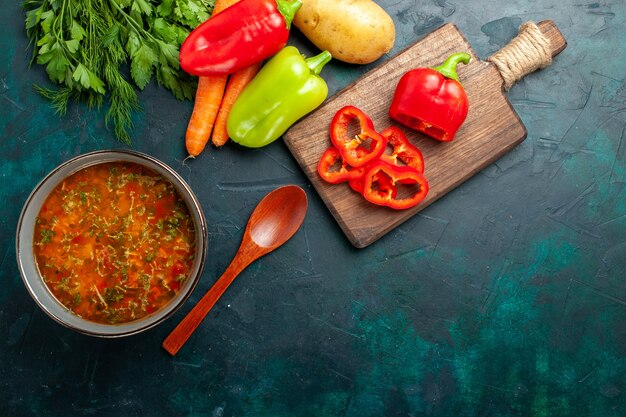 Vue de dessus délicieuse soupe aux légumes avec différents assaisonnements sur la surface vert foncé alimentaire soupe aux légumes ingrédient produit