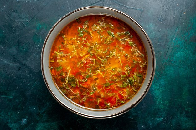 Vue de dessus délicieuse soupe aux légumes à l'intérieur de la plaque sur la surface vert foncé des aliments légumes ingrédients soupe produit repas