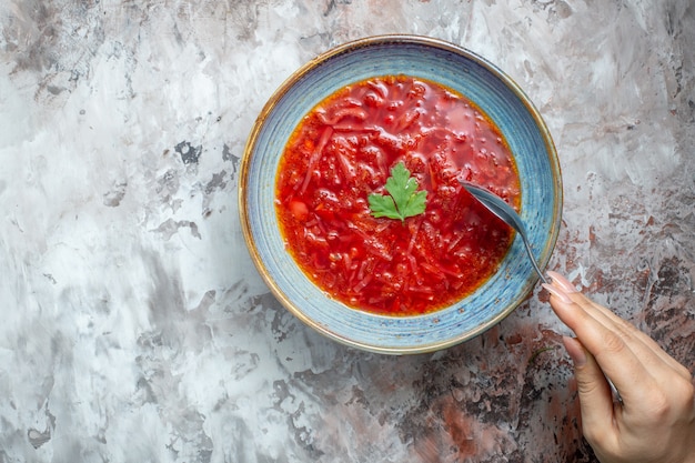 Vue de dessus délicieuse soupe de betterave ukrainienne bortsch à l'intérieur de la plaque sur fond blanc clair