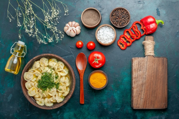 Vue de dessus délicieuse soupe de boulettes avec assaisonnements à l'huile et tomates sur la viande de soupe de repas de nourriture de surface verte