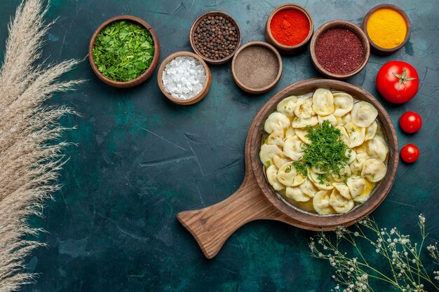 Vue de dessus délicieuse soupe de boulettes avec différents assaisonnements sur la soupe de pâte de légumes de viande de nourriture de surface verte