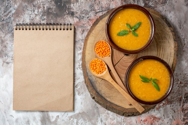 Vue de dessus délicieuse soupe de lentilles à l'intérieur des assiettes sur fond clair soupe de plantes à graines couleur plat de nourriture photo