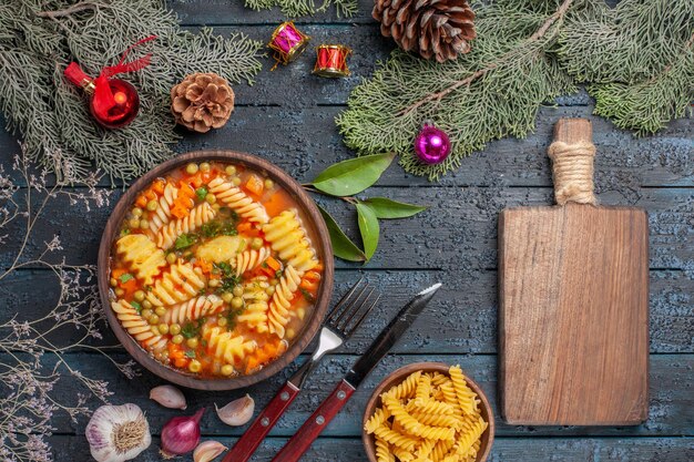 Vue de dessus délicieuse soupe de pâtes à partir de pâtes italiennes en spirale sur le plat de bureau bleu foncé cuisine pâtes à soupe de couleur