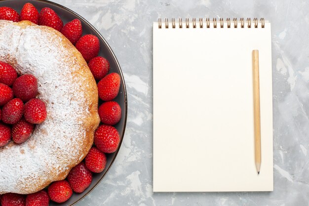 Vue de dessus délicieuse tarte aux fraises avec bloc-notes sur blanc clair