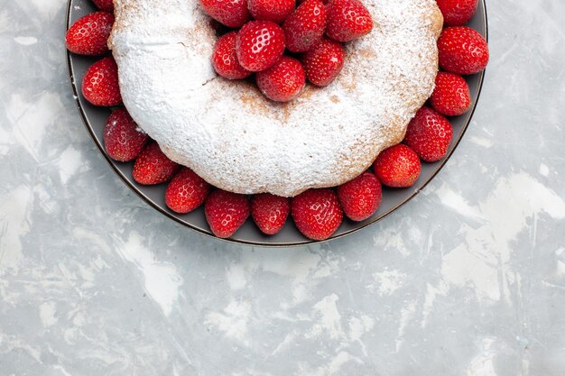 Vue de dessus délicieuse tarte aux fraises avec du sucre en poudre sur blanc clair