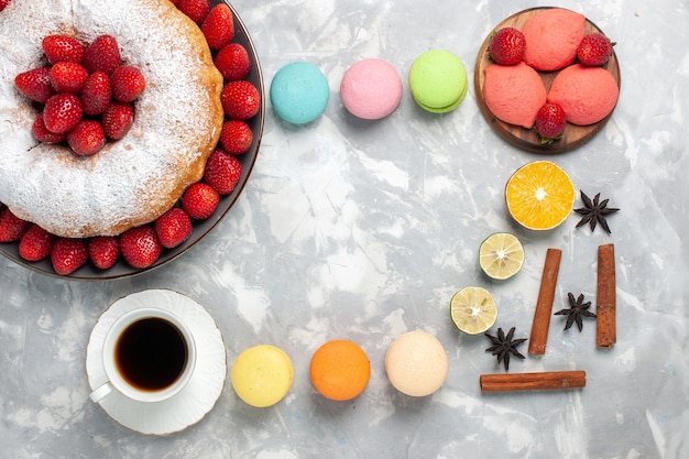 Vue de dessus délicieuse tarte aux fraises avec du thé et des fruits sur blanc