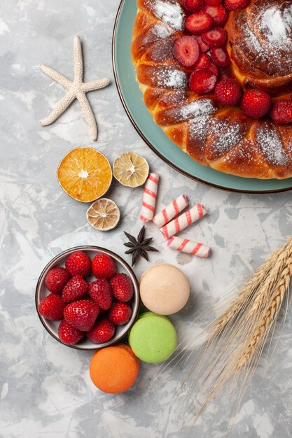 Vue de dessus délicieuse tarte aux fraises avec macarons sur surface légère cuire au four biscuit gâteau sucre tarte sucrée cookie