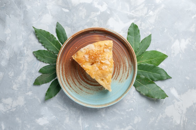 Vue de dessus délicieuse tarte aux pommes à l'intérieur de la plaque sur blanc bureau tarte gâteau biscuit sucre sucré cuire