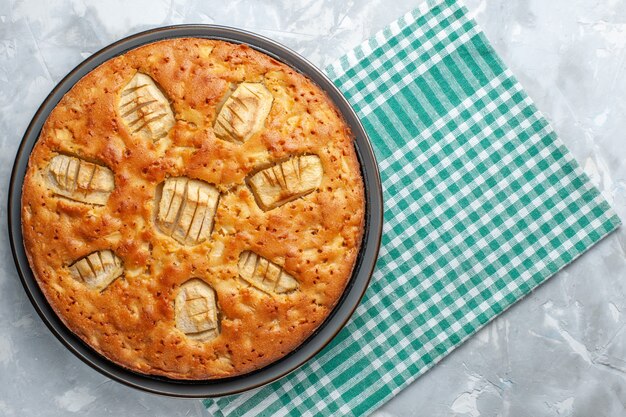 Vue de dessus délicieuse tarte aux pommes sucrée et cuite à l'intérieur de la casserole sur un bureau léger