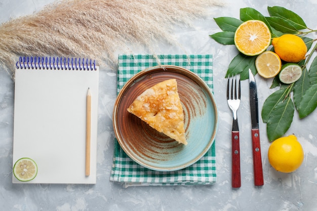 Vue De Dessus Délicieuse Tarte Aux Pommes En Tranches à L'intérieur De La Plaque Avec Des Citrons Sur Le Gâteau De Tarte Léger