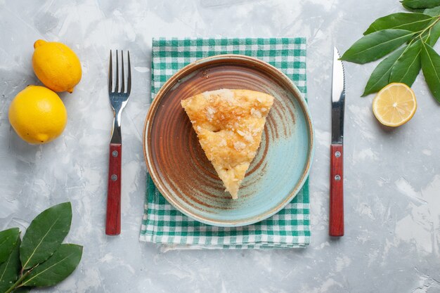 Vue de dessus délicieuse tarte aux pommes en tranches à l'intérieur de la plaque avec du citron sur le bureau blanc gâteau tarte biscuit au sucre sucré