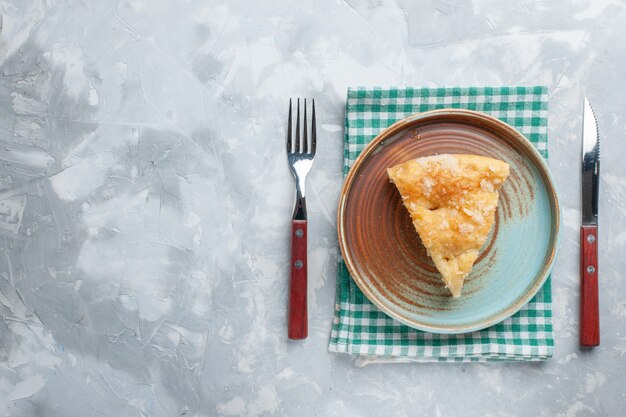 Vue de dessus délicieuse tarte aux pommes en tranches à l'intérieur de la plaque sur le gâteau de tarte de bureau blanc biscuit