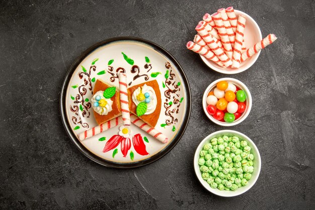 Vue de dessus délicieuse tarte à la crème à l'intérieur d'une assiette conçue avec des bonbons sur fond sombre gâteau tarte à la crème biscuit sucré