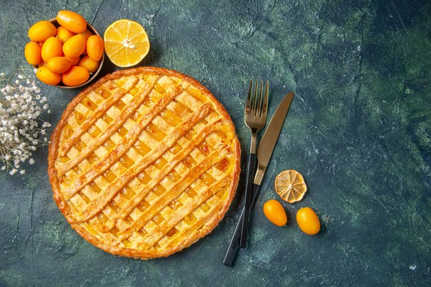 Vue de dessus de la délicieuse tarte à la gelée avec une fourchette et un couteau sur une surface bleu foncé