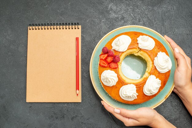 Vue de dessus délicieuse tarte ronde aux fruits et crème sur fond sombre thé biscuits au sucre biscuit gâteau sucré