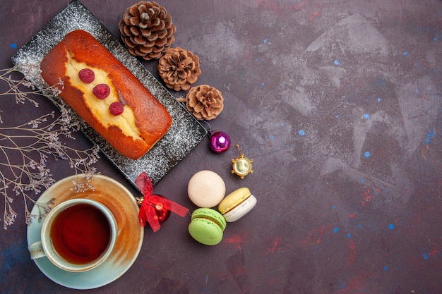 Vue de dessus une délicieuse tarte avec une tasse de thé sur le fond sombre gâteau au sucre tarte aux biscuits thé aux biscuits sucrés