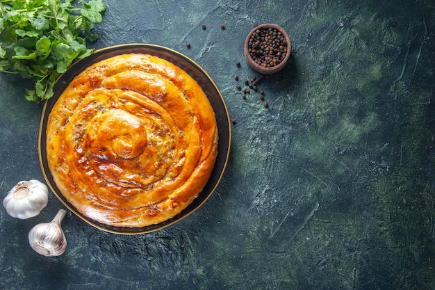 Vue de dessus d'une délicieuse tarte à la viande avec des ingrédients sur une surface sombre