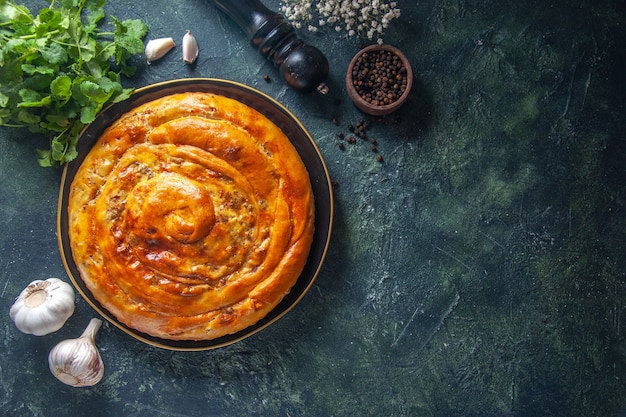 Photo gratuite vue de dessus d'une délicieuse tarte à la viande avec des ingrédients sur une surface sombre