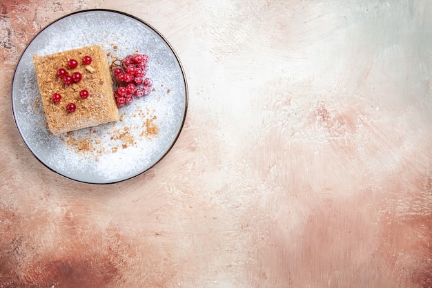 Vue de dessus d'une délicieuse tranche de gâteau avec des baies rouges à la lumière