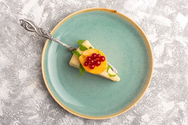 Photo gratuite vue de dessus délicieuse tranche de gâteau avec tranche d'abricot sur le fond blanc gâteau biscuit sucre pâte sucrée cuire au four